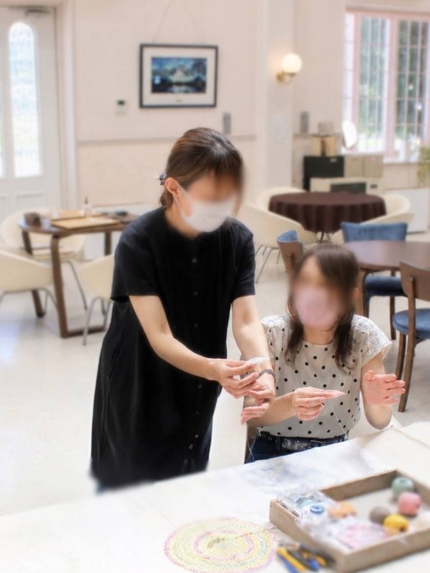 講師が生徒の手元で結び方を伝えている様子