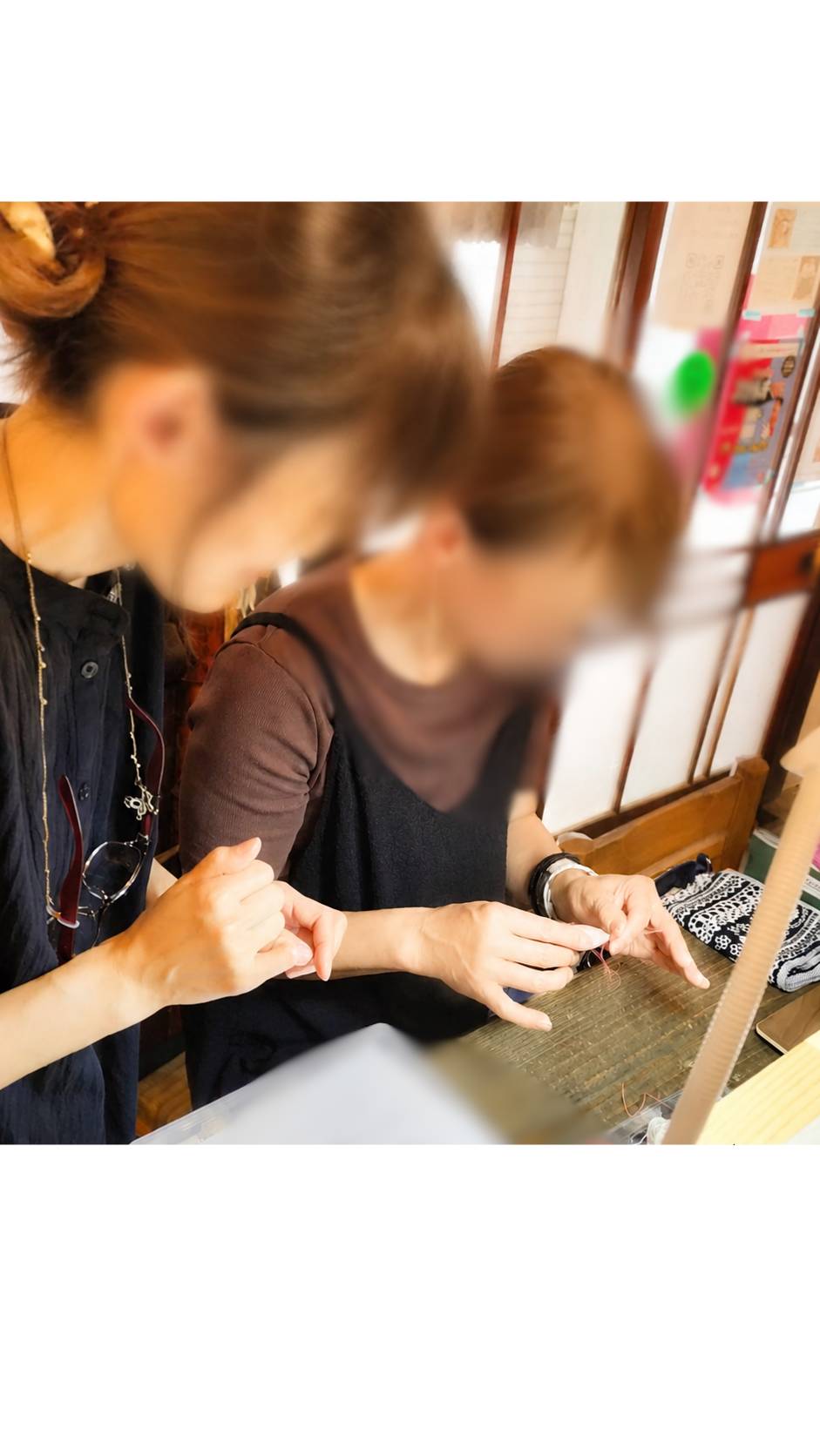 講師と生徒が手元を見ながらタティングレースを進める様子