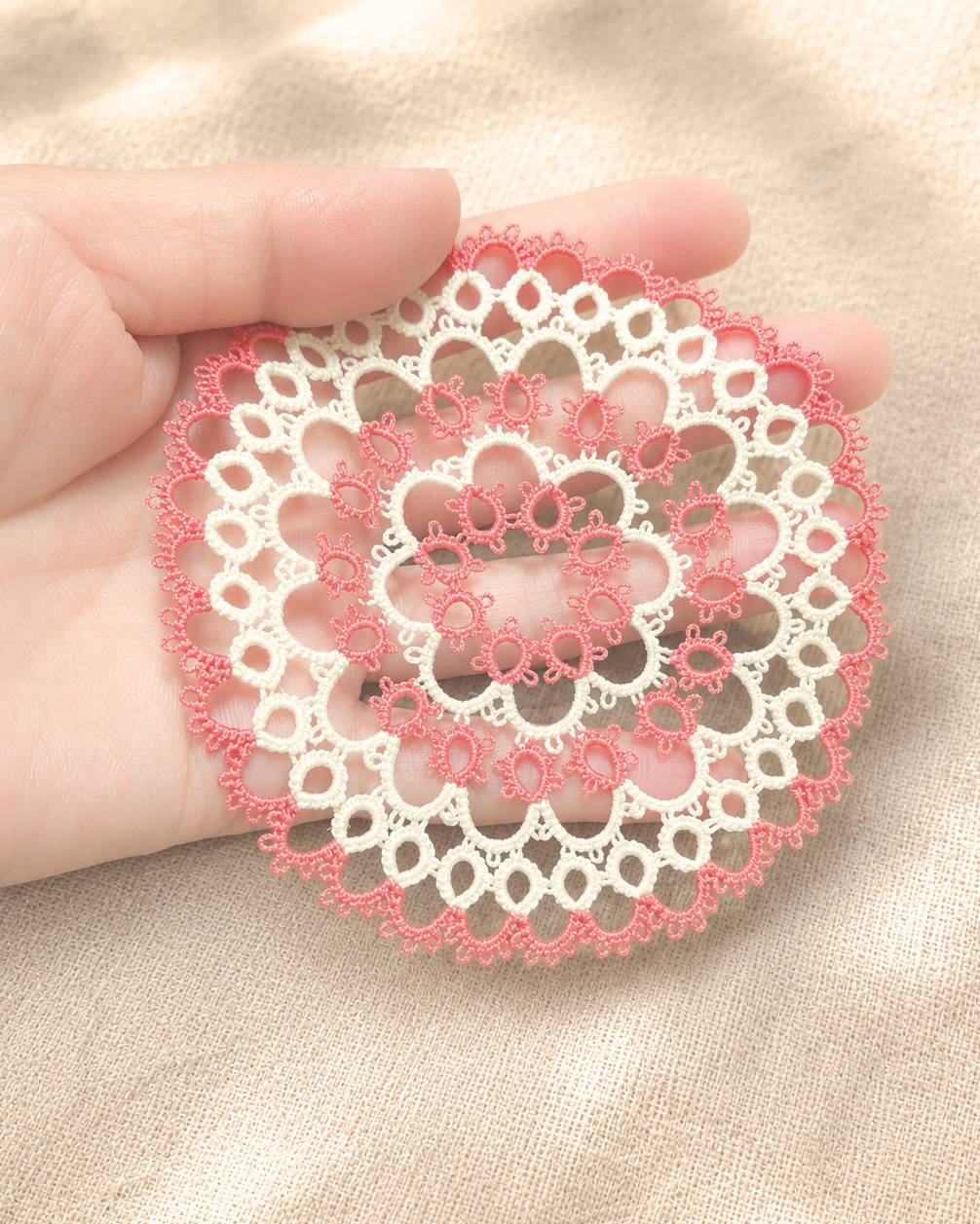 手のひらにのせた紅白のタティングレース作品